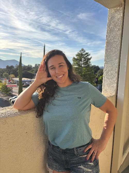 Woman standing on a balcony with a scenic background
