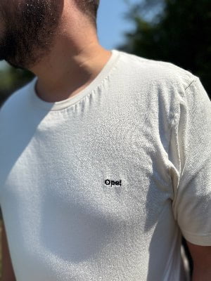 Person wearing a light gray t-shirt with 'Opel' logo outdoors
